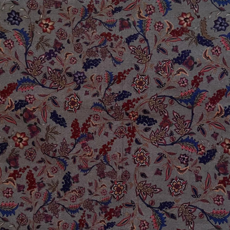 Floral patterned fabric with red, blue, and purple colors on a gray background