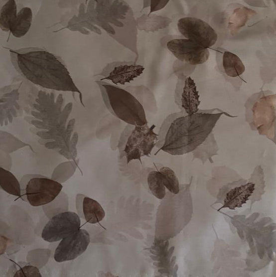 Folded Earthy Tones Scattered Leaf Digital Print Cotton Fabric, showing various brown and grey leaves on a light background, ideal for sustainable dresses, men's shirts, and natural home decor.