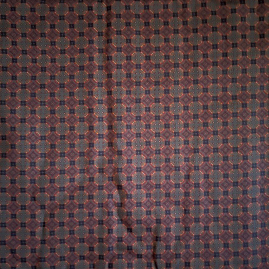 Folded Navy and Rust Micro Geometric Digital Print Cotton Fabric, showing an intricate repeating pattern, ideal for sustainable men's shirts, dresses, and classic home decor.